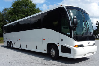 a plain white charter bus parked in a lot